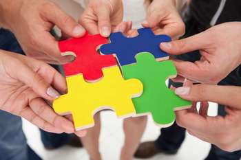 Collaboration symbolized by connecting puzzle pieces.